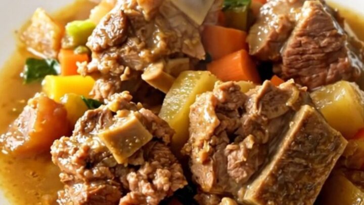 A rustic bowl of Potée Morvandelle featuring tender pork belly, smoked sausages
