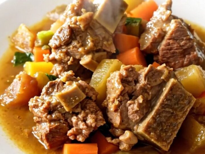 A rustic bowl of Potée Morvandelle featuring tender pork belly, smoked sausages