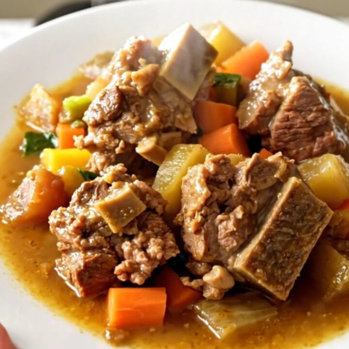 A rustic bowl of Potée Morvandelle featuring tender pork belly, smoked sausages