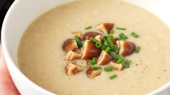 A white bowl filled with creamy, steaming parsnip and chestnut velouté topped with chopped chestnut pieces.