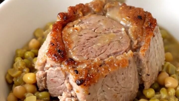 A steaming bowl of tender shredded pork over creamy split peas with diced carrots.