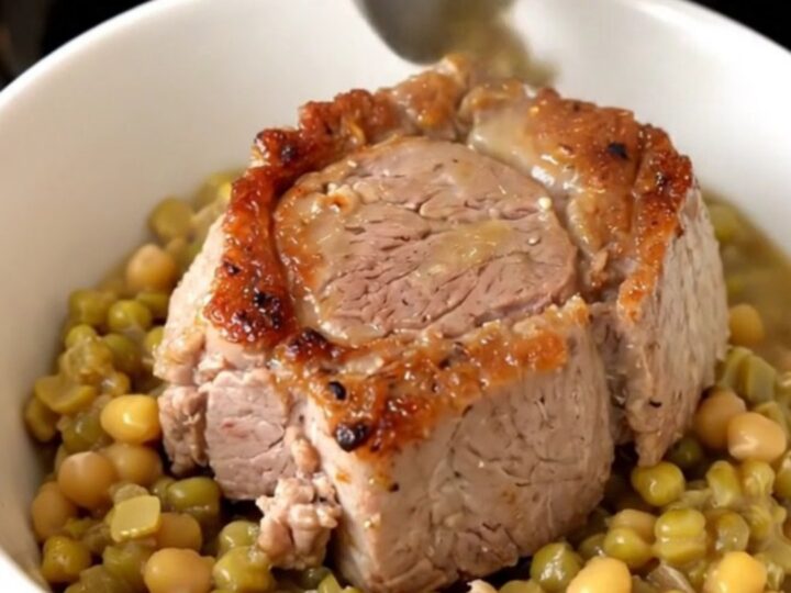 A steaming bowl of tender shredded pork over creamy split peas with diced carrots.