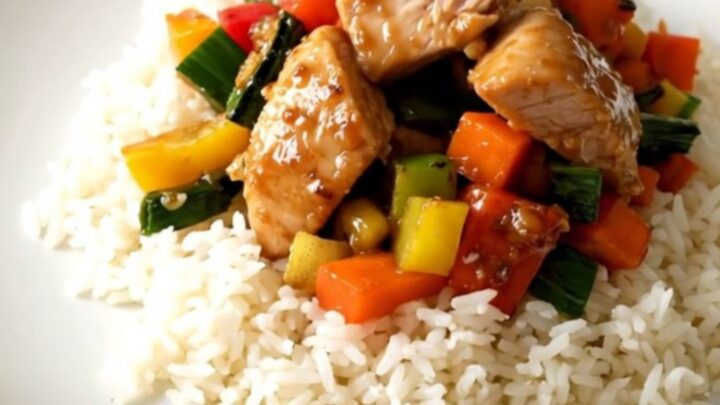 Vue de dessus d'un mijoté de poulet aux carottes et poireaux dans une mijoteuse noire sur un plan de travail en quartz.