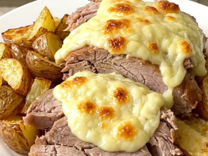 Rôti de porc fondant nappé de cantal fondu et accompagné de pommes de terre dorées dans une mijoteuse.