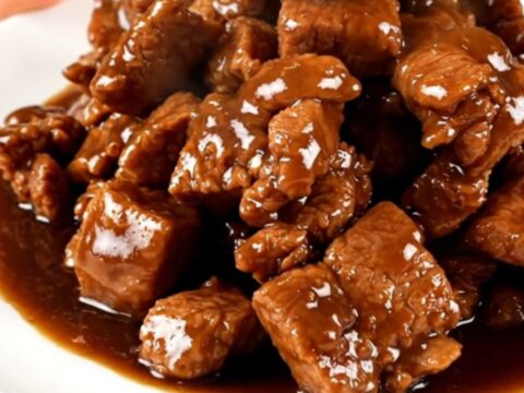 Vue de dessus d'un porc adobo brillant et tendre servi dans une mijoteuse sur un comptoir en quartz.