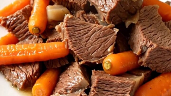 A rustic slow cooker filled with tender braised beef chuck, whole carrots, and halved turnips in a rich broth.