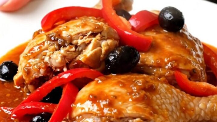 Vue de dessus d'un poulet catalan mijoté avec des poivrons rouges et des olives noires dans une mijoteuse.