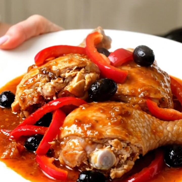 Vue de dessus d'un poulet catalan mijoté avec des poivrons rouges et des olives noires dans une mijoteuse.
