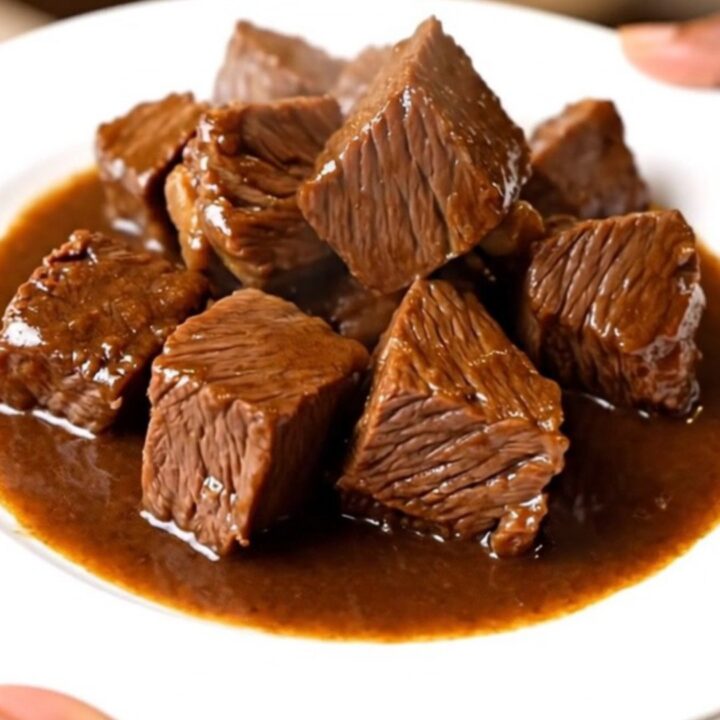 Bœuf fondant mijoté dans une sauce sombre et brillante au vin rouge et ail noir dans une mijoteuse.