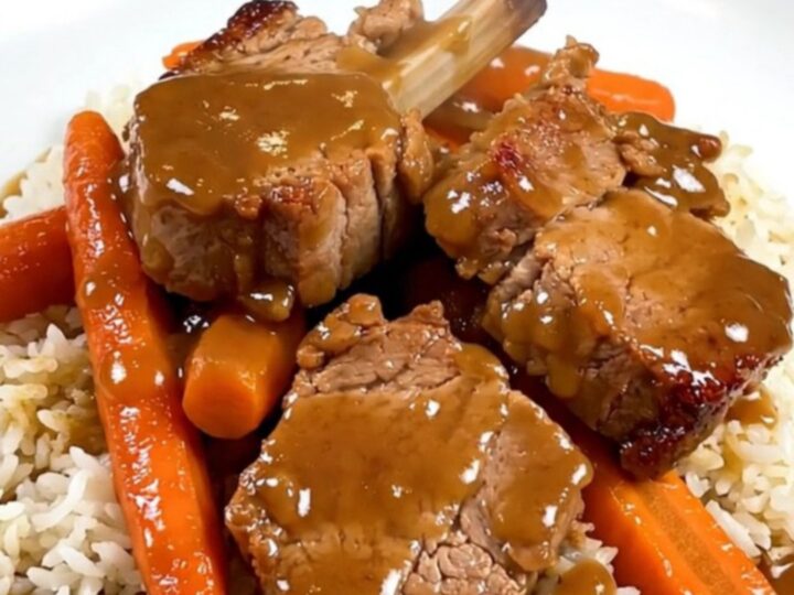 A top-down view of raw pork, carrots, and shallots in a slow cooker insert before cooking.