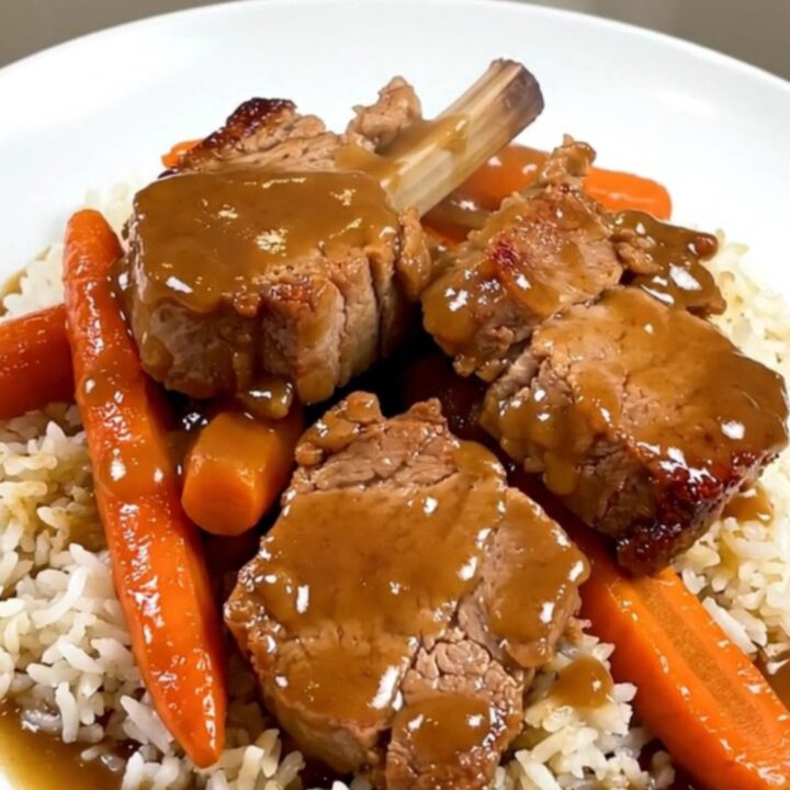 A top-down view of raw pork, carrots, and shallots in a slow cooker insert before cooking.