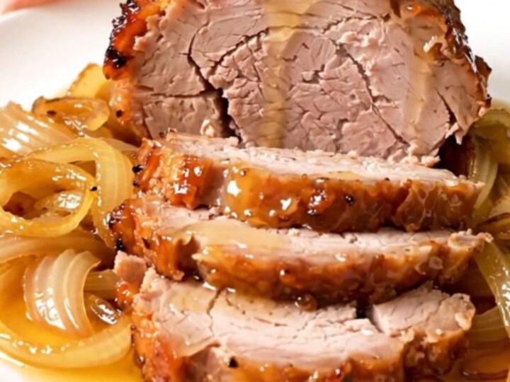 Rouelle de porc fondante nappée d'une sauce brillante au miel et romarin dans une mijoteuse.