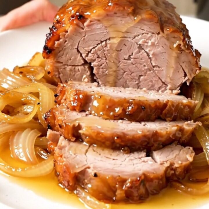 Rouelle de porc fondante nappée d'une sauce brillante au miel et romarin dans une mijoteuse.