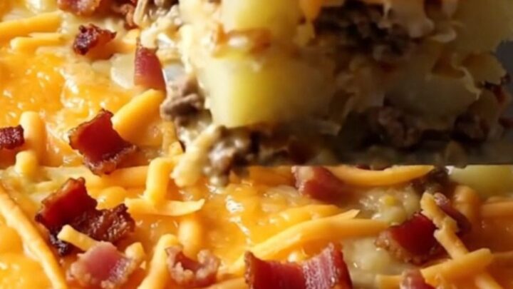 A top-down view of a rectangular baking dish filled with raw ground beef and sliced potatoes, ready for the oven.