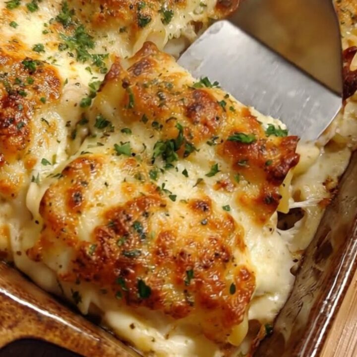 A golden, bubbling creamy garlic parmesan chicken pasta bake in a rustic ceramic pan.