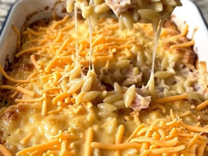 A top-down view of a creamy cheeseburger turkey orzo bake in a white rectangular baker on a granite surface.