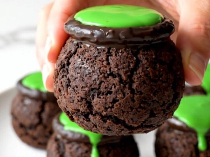 A close-up view of no-bake cookie truffle cauldrons arranged on a white plate.