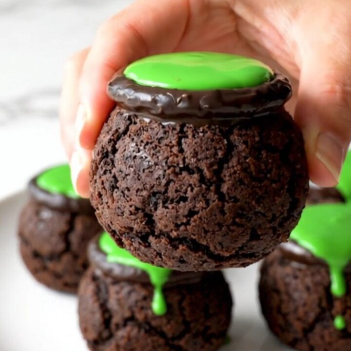 A close-up view of no-bake cookie truffle cauldrons arranged on a white plate.