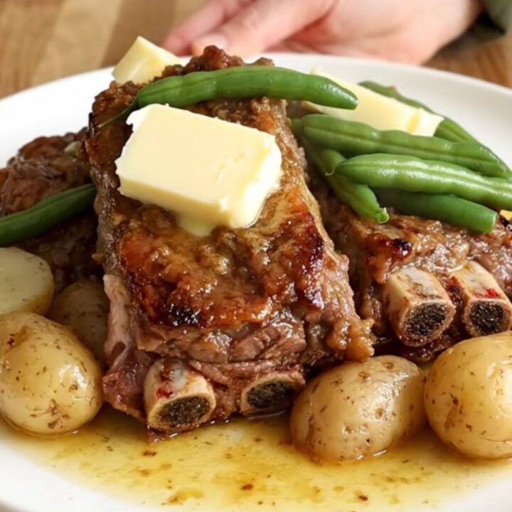 A top-down view of tender country-style pork ribs, green beans, and halved baby potatoes in a slow cooker.
