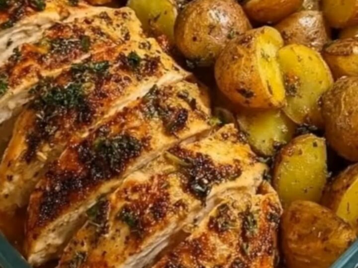 A glass baking dish containing sliced roasted chicken breast, golden baby potatoes, and green beans.
