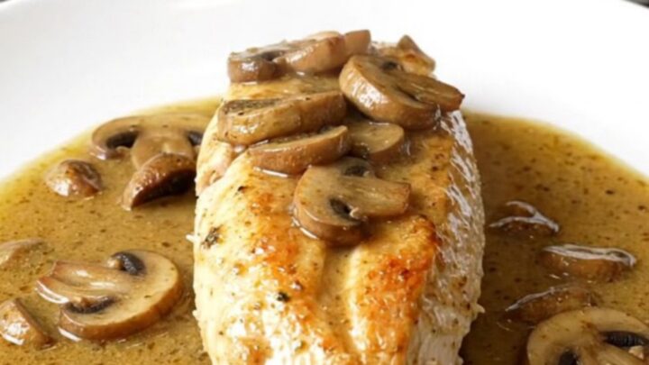 A serving of creamy slow cooker Chicken Marsala with mushrooms on a white plate.