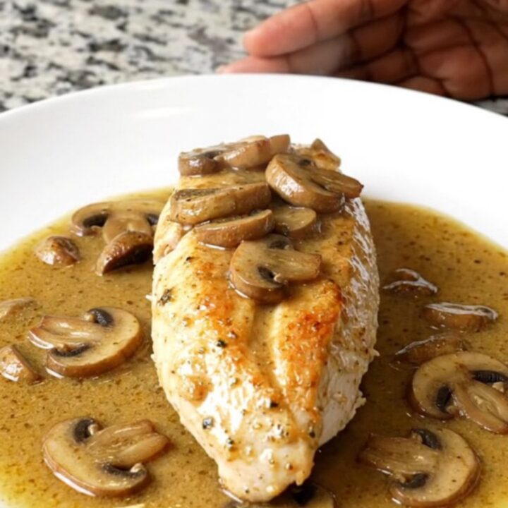 A serving of creamy slow cooker Chicken Marsala with mushrooms on a white plate.