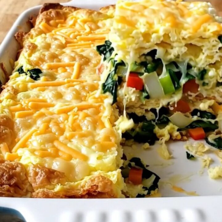 A freshly baked cottage cheese veggie egg bake in a white ceramic dish, featuring colorful peppers, spinach