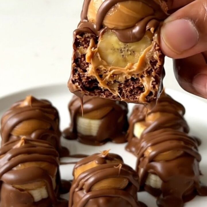 A close-up view of peanut butter chocolate banana bites arranged on a white plate.