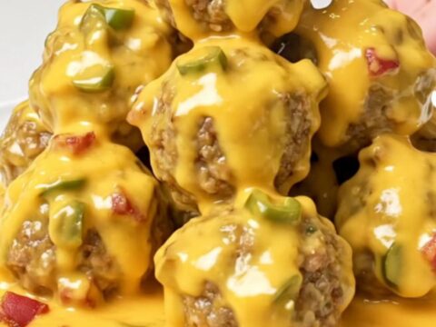 A close-up of tender turkey meatballs generously coated in a thick
