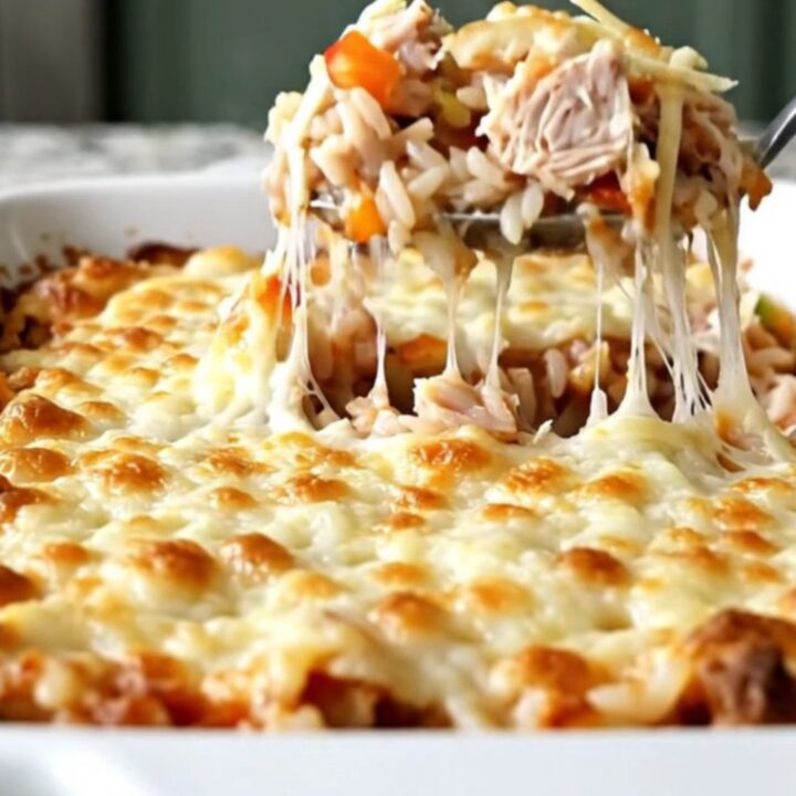 A top-down view of a stuffed pepper casserole with melted mozzarella cheese in a rectangular white baking dish.