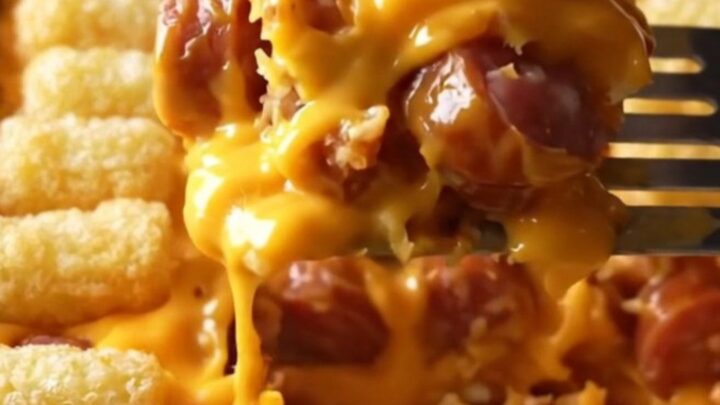 A top-down view of a golden, crispy potato tot casserole in a rectangular ceramic baking dish.