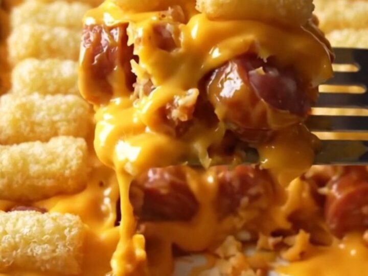 A top-down view of a golden, crispy potato tot casserole in a rectangular ceramic baking dish.