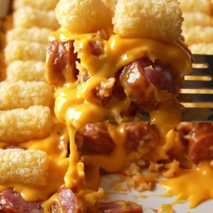 A top-down view of a golden, crispy potato tot casserole in a rectangular ceramic baking dish.