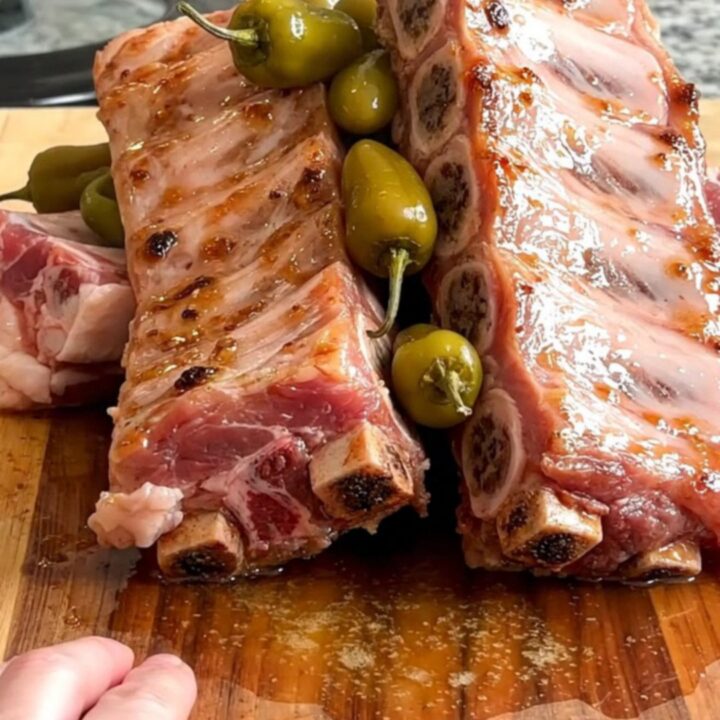 A slow cooker filled with tender boneless country-style pork ribs and whole pepperoncini peppers.