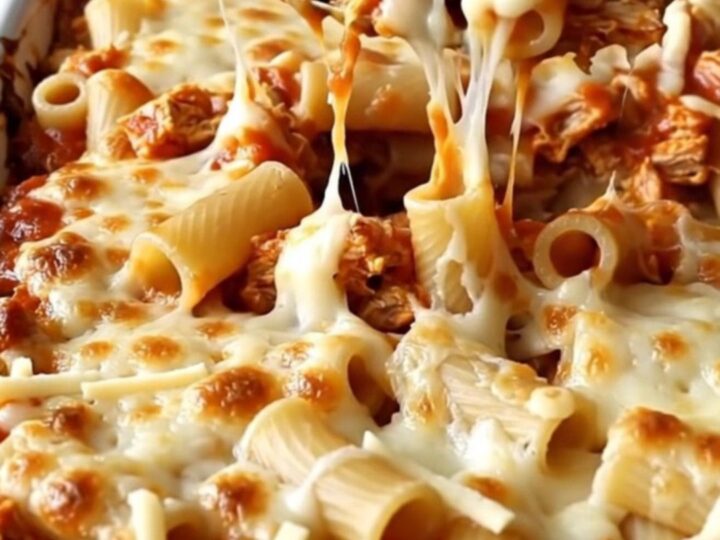 A large rectangular ceramic dish filled with baked ziti, ground turkey, and bubbly, melted mozzarella cheese.
