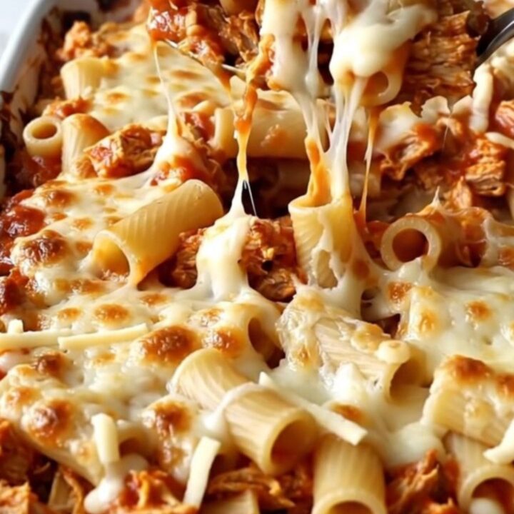 A large rectangular ceramic dish filled with baked ziti, ground turkey, and bubbly, melted mozzarella cheese.
