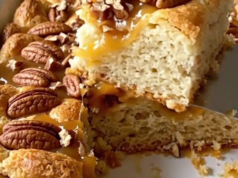 A top-down view of a rectangular baking dish filled with golden-brown, puffed biscuit pieces and a rich