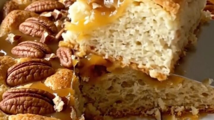 A top-down view of a rectangular baking dish filled with golden-brown, puffed biscuit pieces and a rich