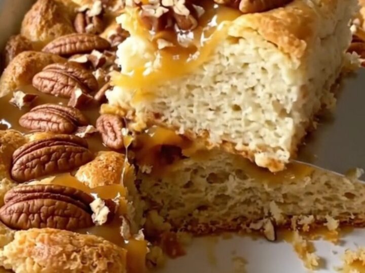 A top-down view of a rectangular baking dish filled with golden-brown, puffed biscuit pieces and a rich