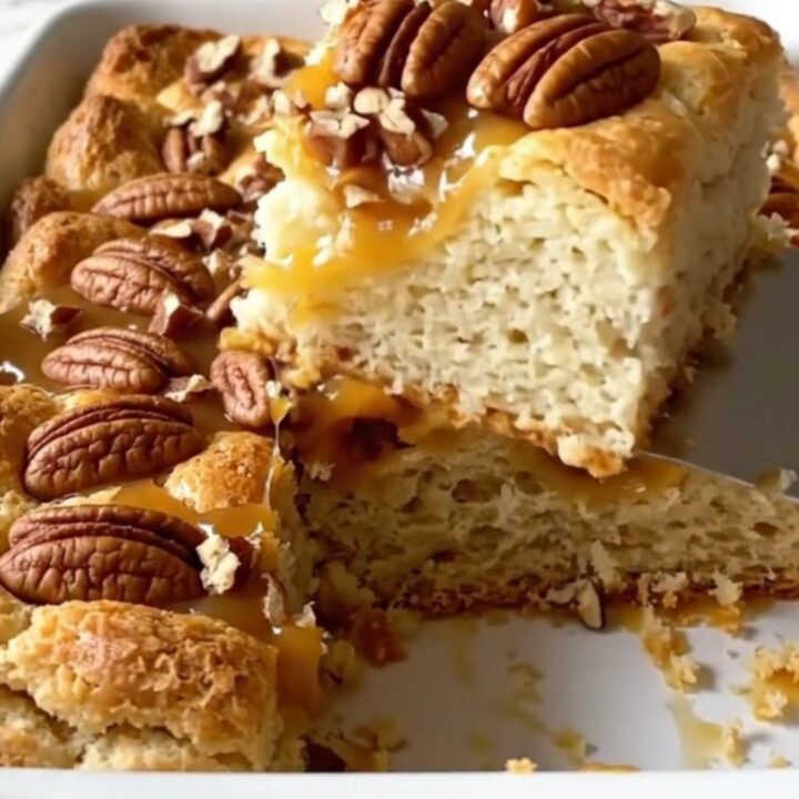 A top-down view of a rectangular baking dish filled with golden-brown, puffed biscuit pieces and a rich