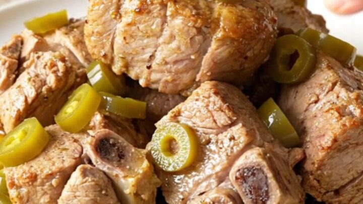 A close-up shot of a tender, slow-cooked Mississippi pork roast with pepperoncini in a slow cooker.