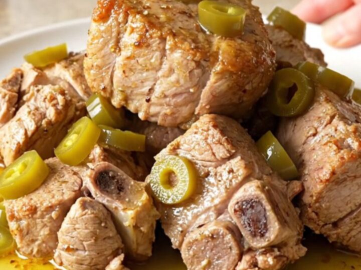A close-up shot of a tender, slow-cooked Mississippi pork roast with pepperoncini in a slow cooker.