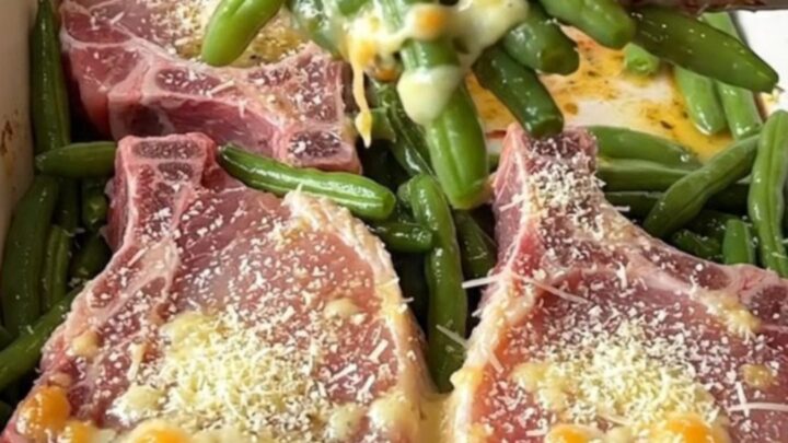 A top-down view of a rectangular baking dish filled with raw pork chops and fresh green beans, ready for the oven.