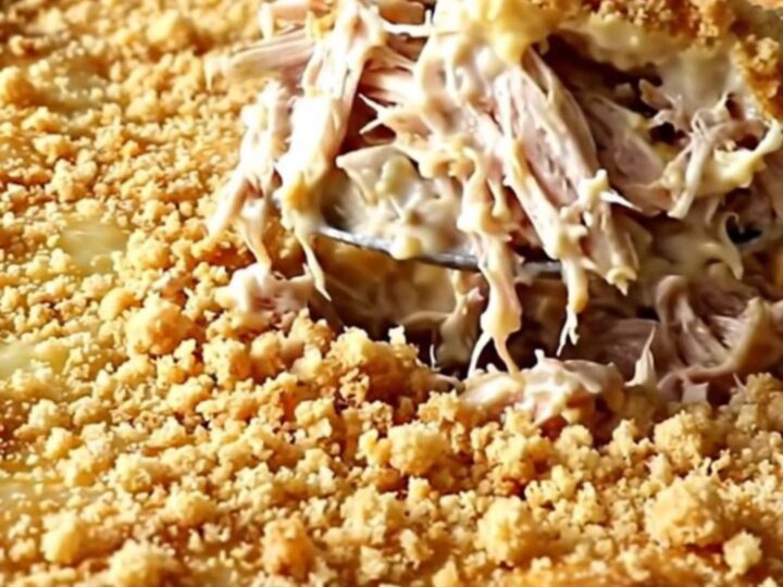 A golden, crunchy cracker-topped chicken casserole in a white ceramic dish.