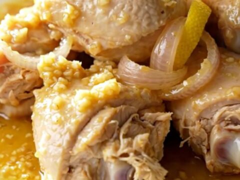Slow cooker chicken scampi with lemon slices and shallots in a garlic butter sauce.
