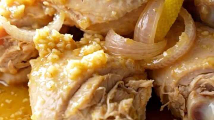 Slow cooker chicken scampi with lemon slices and shallots in a garlic butter sauce.