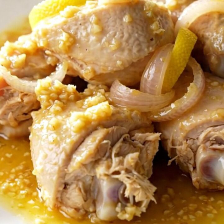 Slow cooker chicken scampi with lemon slices and shallots in a garlic butter sauce.