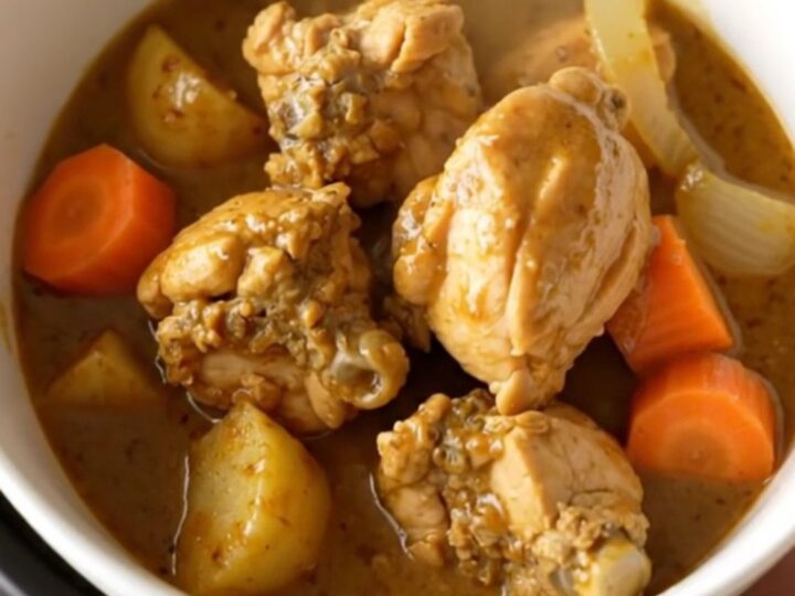 A bowl of Japanese chicken curry with chunks of potato and carrot in a rich brown sauce.