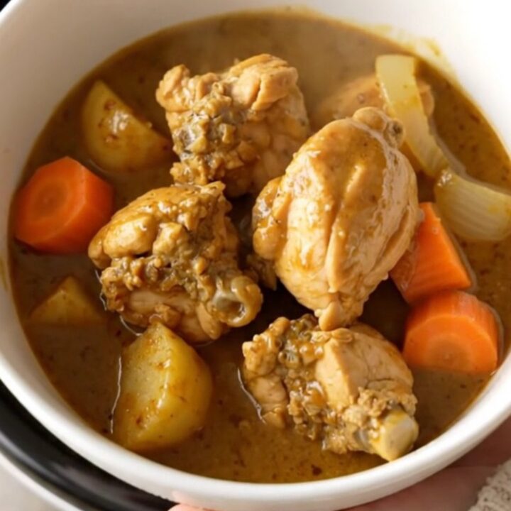 A bowl of Japanese chicken curry with chunks of potato and carrot in a rich brown sauce.