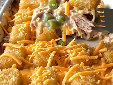 A top-down view of a rectangular baking dish filled with a creamy turkey and green bean base